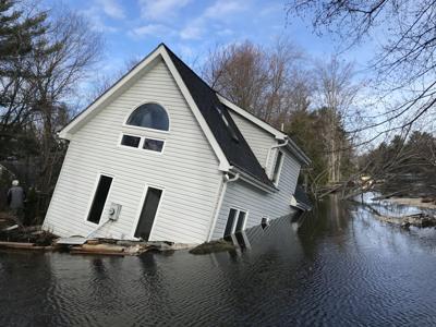 House half submerged in river